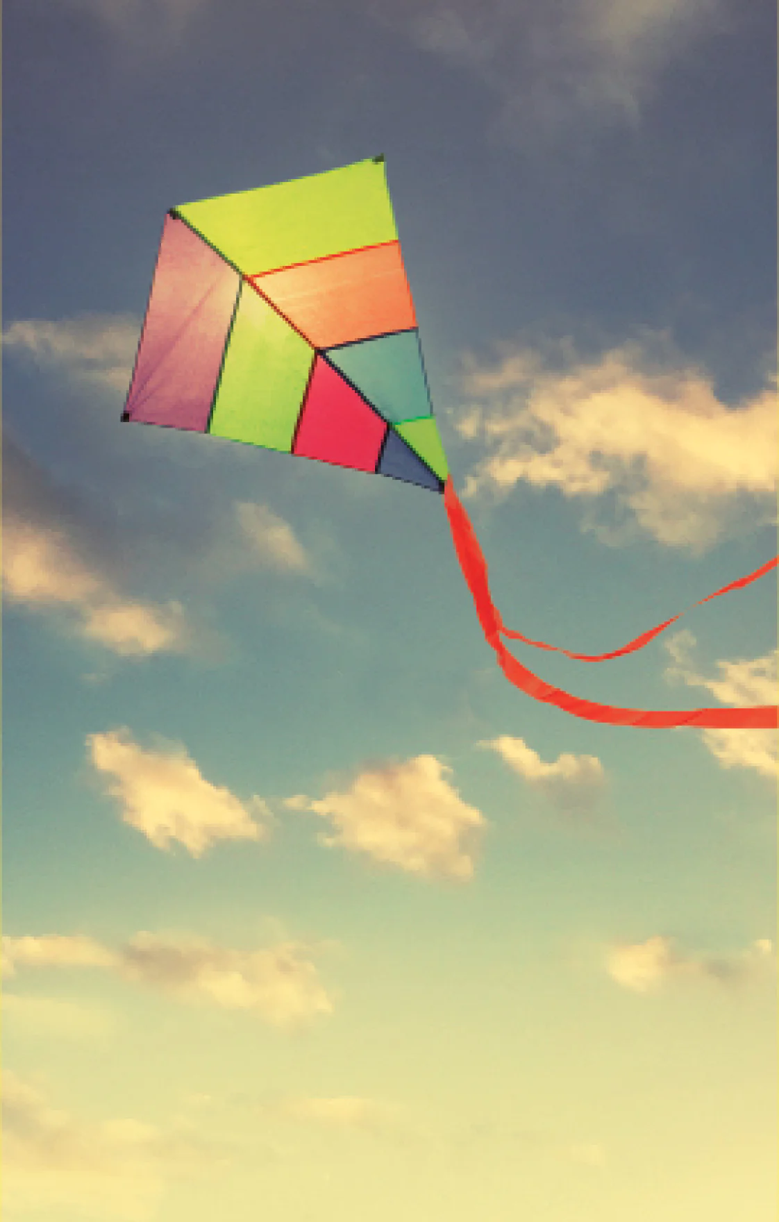 Pipa colorida voando em um céu com nuvens